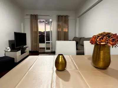 a living room with a table with two gold vases on it at SÃO GONÇALO APARTAMENTO in Funchal