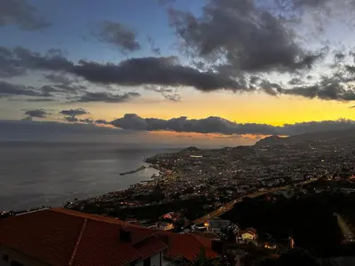 a view of a city at sunset with the ocean at SÃO GONÇALO APARTAMENTO in Funchal