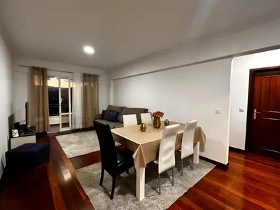 a living room with a table and a couch at SÃO GONÇALO APARTAMENTO in Funchal