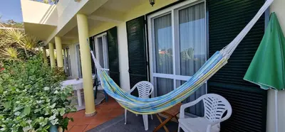 a hammock on the porch of a house at Sunny Arco Retreat in Arco da Calheta