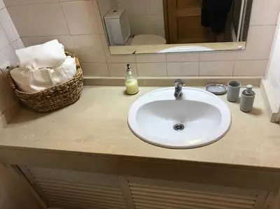 a bathroom counter with a white sink and a mirror at Gemini Apartment by AM in Funchal