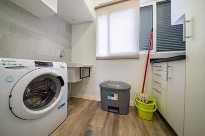 a laundry room with a washing machine and a trash can at Casa da Clara by MTH in Caniço