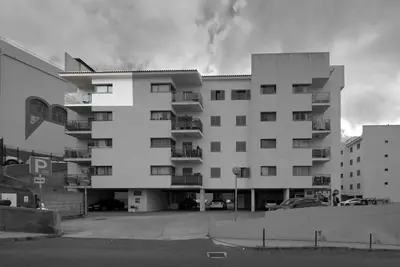 a large white apartment building with a parking lot at Casa da Clara by MTH in Caniço