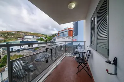 a balcony with a table and chairs on a building at Casa da Clara by MTH in Caniço