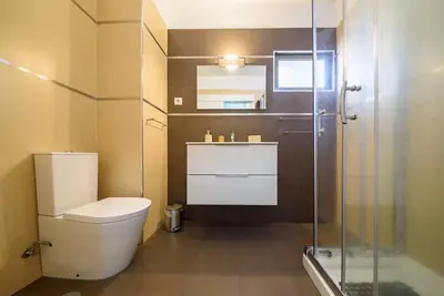 a bathroom with a toilet and a glass shower at Casa da Clara by MTH in Caniço