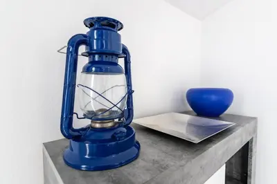 a blue lantern sitting on a table with a blue vase at Esterinha's Sunset Apartment by GALMI in Estreito da Calheta