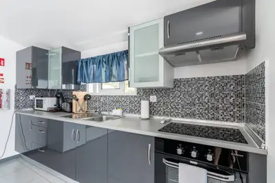 a kitchen with a sink and a stove top oven at Esterinha's Sunset Apartment by GALMI in Estreito da Calheta