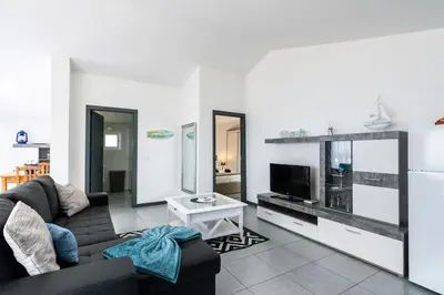 a living room with a couch and a tv at Esterinha's Sunset Apartment by GALMI in Estreito da Calheta