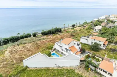 an aerial view of a house and the ocean at Esterinha's Sunset Apartment by GALMI in Estreito da Calheta