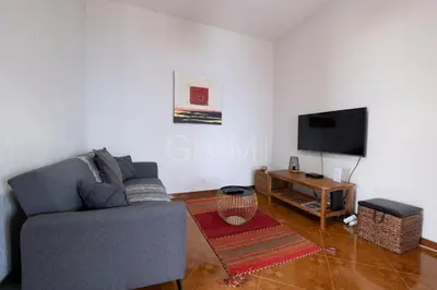 a living room with a couch and a tv at De Casa Villa by GALMI in Estreito da Calheta