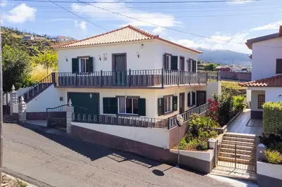 a large white house with a balcony at Villa Pequenino by GALMI in Estreito da Calheta