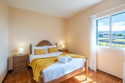 a bedroom with a bed and a large window at Villa Pequenino by GALMI in Estreito da Calheta