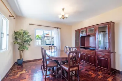 a dining room with a table and a tv at Villa Pequenino by GALMI in Estreito da Calheta