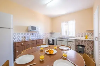 a kitchen with a wooden table with glasses of orange juice at Villa Pequenino by GALMI in Estreito da Calheta