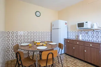 a kitchen with a table with chairs and a refrigerator at Villa Pequenino by GALMI in Estreito da Calheta
