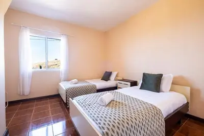 a room with two beds and a window at Villa Pequenino by GALMI in Estreito da Calheta
