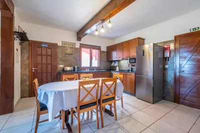 a kitchen with a table and chairs and a refrigerator at Casa del Mar II by GALMI in Arco de São Jorge