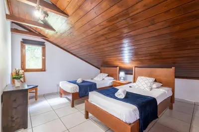 two beds in a room with a wooden ceiling at Casa del Mar II by GALMI in Arco de São Jorge