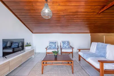 a living room with a couch and a tv at Casa del Mar II by GALMI in Arco de São Jorge