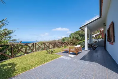 a patio with a bench and a view of the ocean at Casa del Mar II by GALMI in Arco de São Jorge