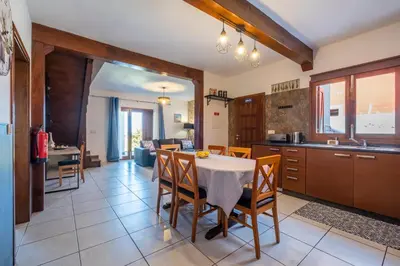 a kitchen and dining room with a table and chairs at Casa del Mar II by GALMI in Arco de São Jorge