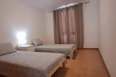 a room with two beds and a window at Casa das Lombas in Vila Baleira