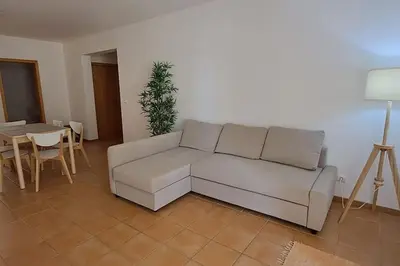a living room with a white couch and a table at Casa das Lombas in Vila Baleira
