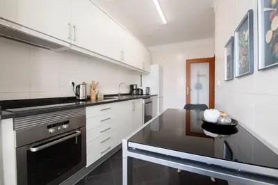 a kitchen with a counter and a table in it at Comfy & Joyful Oceanview Retreat in Caniço