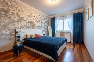 a bedroom with a bed with a blue comforter at Comfy & Joyful Oceanview Retreat in Caniço