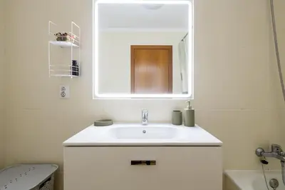 a bathroom with a white sink and a mirror at Comfy & Joyful Oceanview Retreat in Caniço