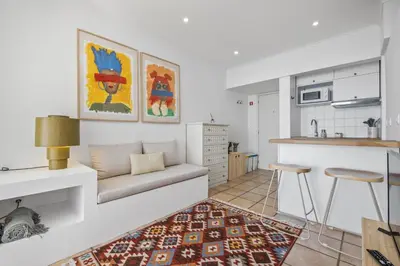 a living room with a couch and a kitchen at Studio Mar - By WeHost in Funchal