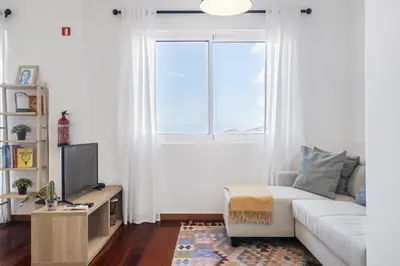 a living room with a white couch and a window at Casa da Angela - By WeHost in Funchal