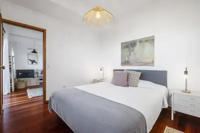 a bedroom with a white bed and a chandelier at Casa da Angela - By WeHost in Funchal