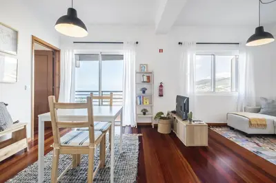 a living room with a table and a bedroom at Casa da Angela - By WeHost in Funchal