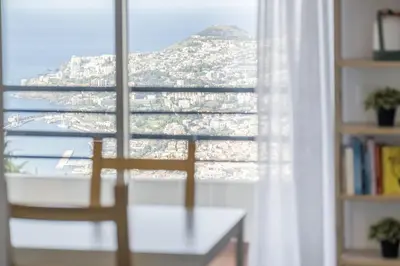 a room with a window with a view of a mountain at Casa da Angela - By WeHost in Funchal