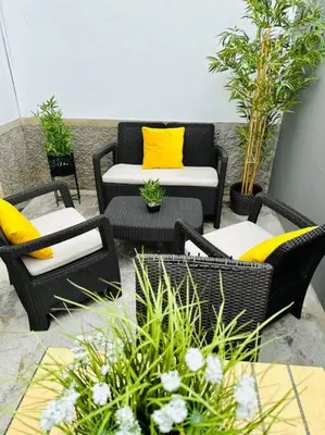 a patio with chairs and tables with yellow pillows at Casa Branca Apartment in Funchal in Funchal