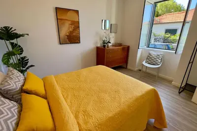 a bedroom with a bed and a dresser and a window at Casa Branca Apartment in Funchal in Funchal
