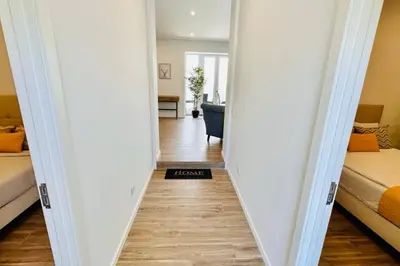a hallway leading to a bedroom with two beds and a mirror at Casa Branca Apartment in Funchal in Funchal