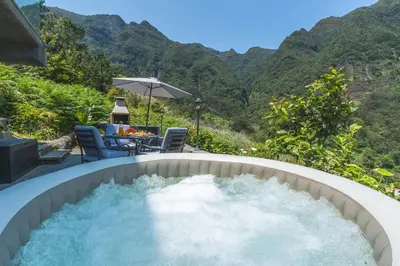 a plunge pool with water in a backyard with mountains at Mystic Mountain by Atlantic Holiday in São Vicente