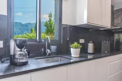 a kitchen counter with a sink and a window at Mystic Mountain by Atlantic Holiday in São Vicente