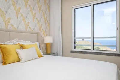 a bedroom with a bed with yellow pillows and a window at Hideaway Apartment by Homie in Caniço