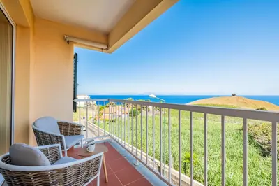 a balcony with chairs and a view of the ocean at Hideaway Apartment by Homie in Caniço