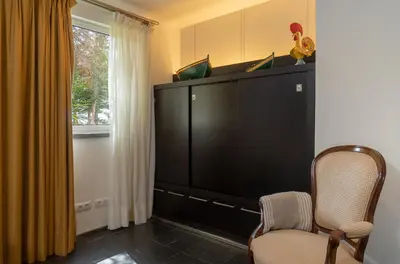 a room with a tv and a chair and a window at By the Atlantic Apartments 3-bedroom in Funchal