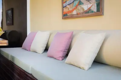 three pillows sitting on a couch under a painting at By the Atlantic Apartments 3-bedroom in Funchal