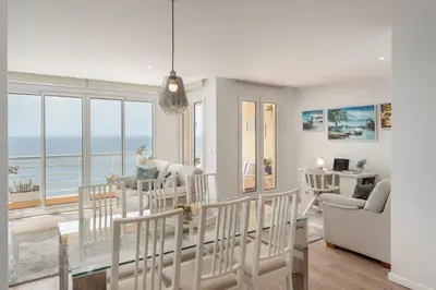 a living room with a table and chairs and the ocean at Vista Formosa I by An Island Apart in Funchal