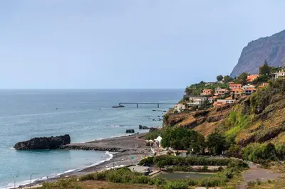 a beach with houses on a hill next to the ocean at Vista Formosa I by An Island Apart in Funchal