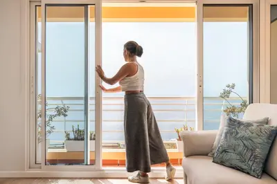 a woman is looking out the window at the ocean at Vista Formosa I by An Island Apart in Funchal