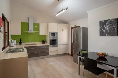 a kitchen with a refrigerator and a table in it at Villa Areal Porto Santo - By An Island Apart in Porto Santo