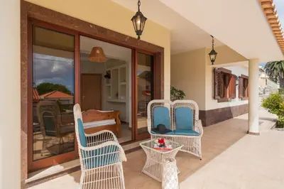 a patio with wicker chairs and a table and a piano at Villa Areal Porto Santo - By An Island Apart in Porto Santo