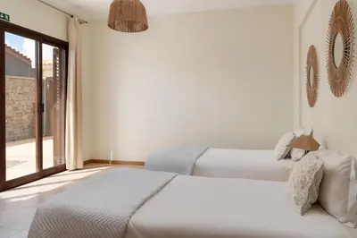 two beds in a room with a window at Villa Areal Porto Santo - By An Island Apart in Porto Santo